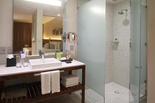 a bathroom with a sink and a shower at Emporio Cancun - Buy All Inclusive Option in Cancún