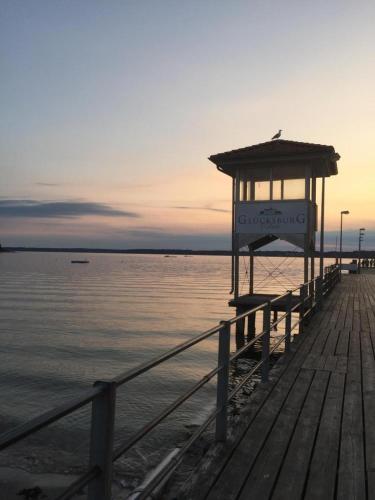 a wooden pier with a gazebo on the water at Ferienwohnung Strandliebe in Glücksburg