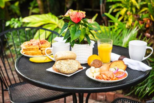 een zwarte tafel met borden ontbijtproducten en jus d'orange bij Old Town Manor in Key West