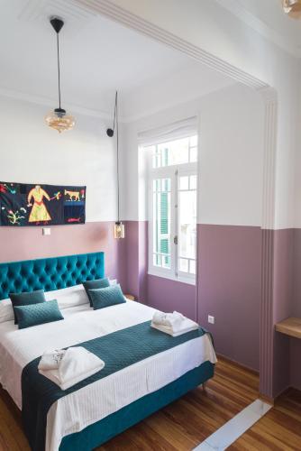 a bedroom with a large bed with purple and purple walls at Neratzia Rooms in Athens