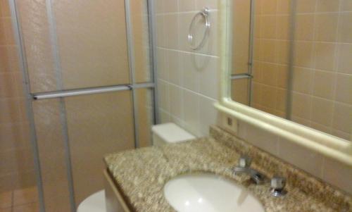 y baño con lavabo y ducha. en V. Gaivota 1 quarto, en Florianópolis