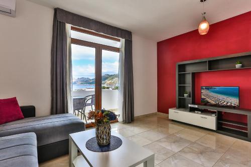 a living room with a couch and a tv at Apartments Sidro in Dobra Voda