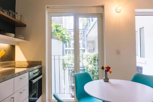 a kitchen with a white table and blue chairs at MyPlace Zocalo in Mexico City