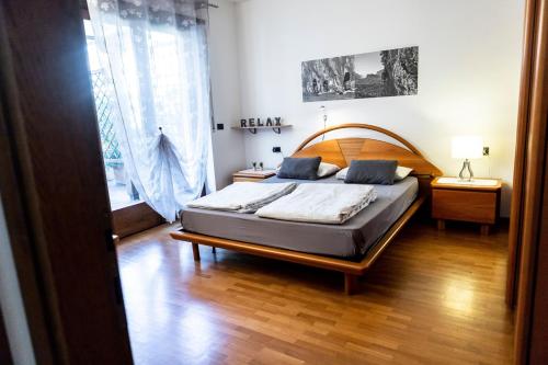 a bedroom with a large bed with a wooden headboard at Appartamento la Terrazza in Arco