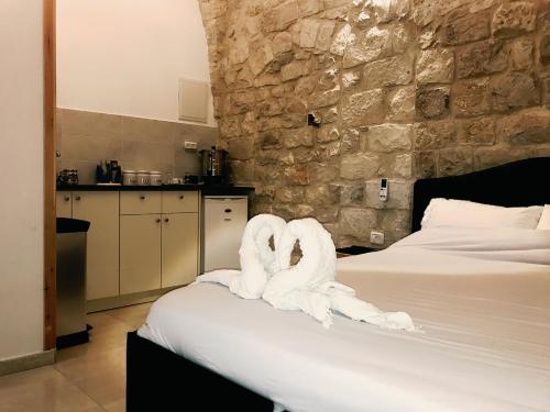 dois cisnes feitos de toalhas sentadas numa cama em Mendy's Accommodation em Safed