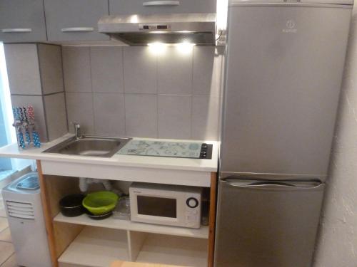 a small kitchen with a refrigerator and a microwave at Ia Ora Na in Fréjus