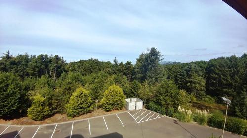 an empty parking lot with trees in the background at Palace Inn & Suites in Lincoln City