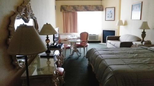 a hotel room with a bed and a living room at Palace Inn & Suites in Lincoln City