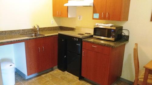 a small kitchen with a microwave and a sink at Palace Inn & Suites in Lincoln City