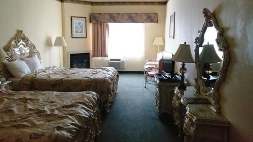 a hotel room with two beds and a mirror at Palace Inn & Suites in Lincoln City