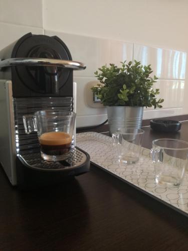 a coffee maker and two glasses on a counter at L`ATTICO Apartments in Civitanova Marche