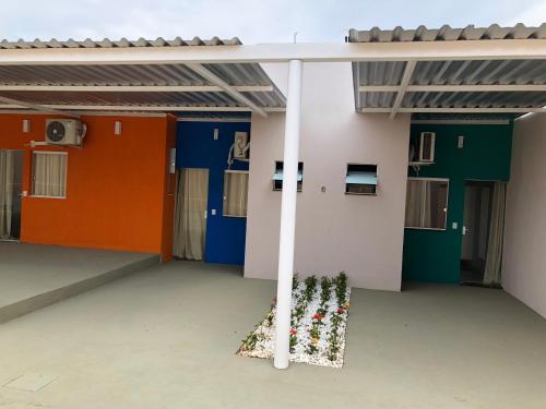 a building with colorful doors and plants in the middle at Pousada Xero in Capitólio
