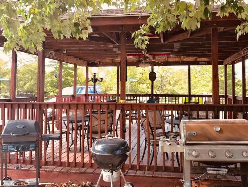 a grill and smoker on a wooden deck with a bar at Hunter's Friend Resort on Indian Point in Branson
