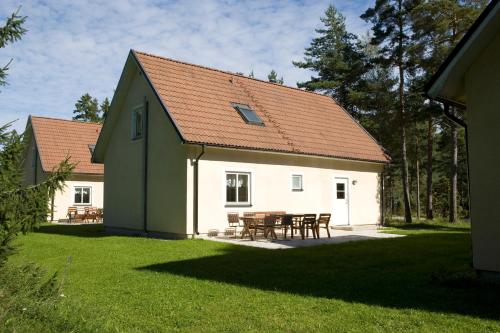 a white house with a table and chairs in a yard at Åminne Fritid & Havsbad AB in Åminne