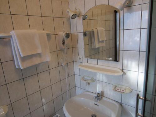 a white bathroom with a sink and a mirror at Livonija in Sigulda