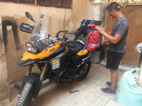 a man is standing next to a motorcycle at david hostel in Aswan