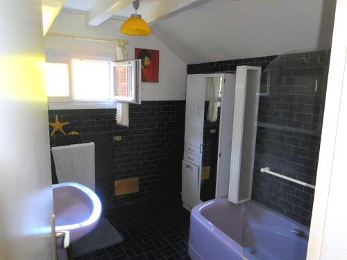 a bathroom with a purple tub and a sink at " d'une Eure à l'autre " in Sainte-Gemme-Moronval