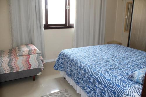 um quarto com uma cama e uma janela em Residencial Hannah - Casa 6 - Porto Belo SC - Bairro Perequê em Porto Belo