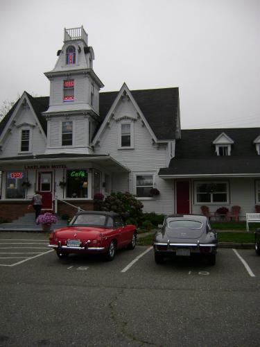 two old cars parked in a parking lot in front of a building at Lakelawn B&B and Motel in Yarmouth