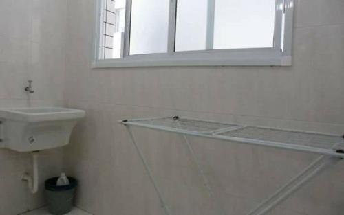 uma casa de banho com um lavatório e uma prateleira de vidro em Recanto do Guerreiro na Praia Grande