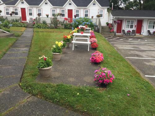 a table in a yard with flowers in pots at Lakelawn B&B and Motel in Yarmouth