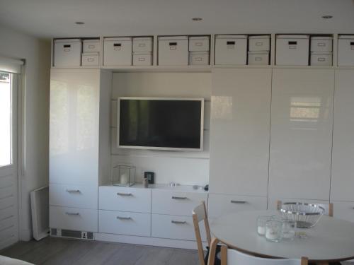 a white kitchen with a table and a tv at Aan de Vecht in Nederhorst den Berg