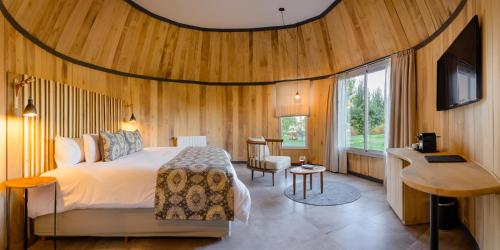1 dormitorio con 1 cama en una habitación con paredes de madera en Villa Mansa en Vistalba
