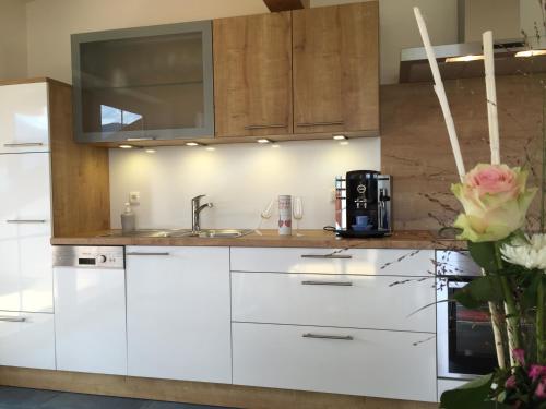 a kitchen with white cabinets and a sink at Alpenglück de Luxe Ferienwohnung am Forggensee in Schwangau
