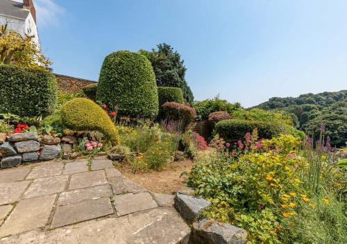 a garden with many different flowers and bushes at Pandora Hotel in St Peter Port