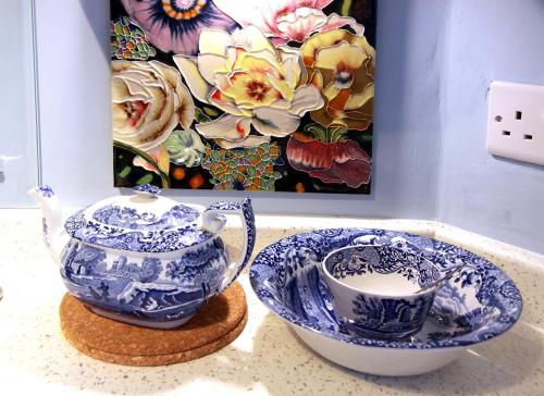 zwei blaue und weiße Tassen und eine Teekanne auf der Theke in der Unterkunft Smugglers Cottage in Hastings