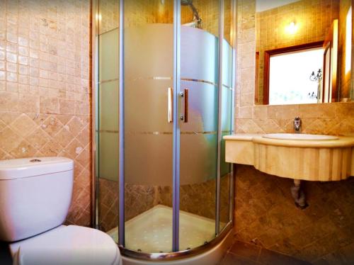 een badkamer met een douche, een toilet en een wastafel bij Quinta Da Ilda in Loulé