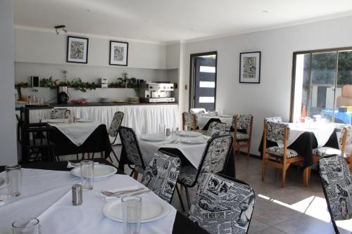 a dining room with tables and chairs with white tablecloths at Hotel Maquehue in Concepción