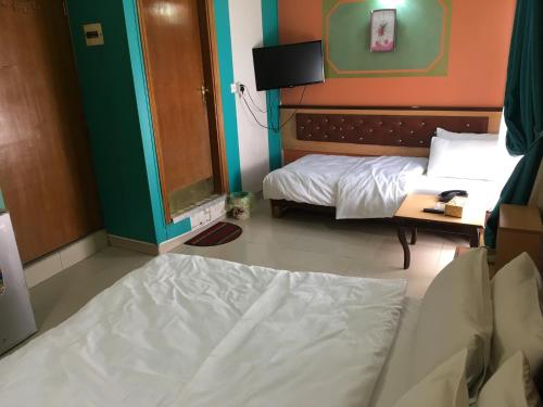 a bedroom with a bed and a tv in it at Dijlat Al Khair Hotel فندق دجلة الخير in Baghdad