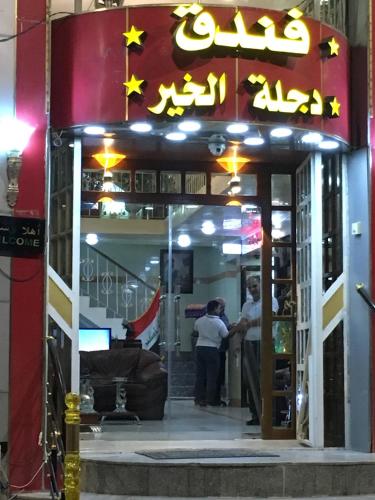 two men standing outside of a restaurant at night at Dijlat Al Khair Hotel فندق دجلة الخير in Baghdad