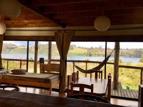 a room with a hammock and a view of a river at Antuquelen Lodge Cabañas in Frutillar