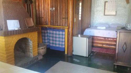 a toy bedroom with a bed and a fireplace at A Casinha Pequenina in Monte Verde