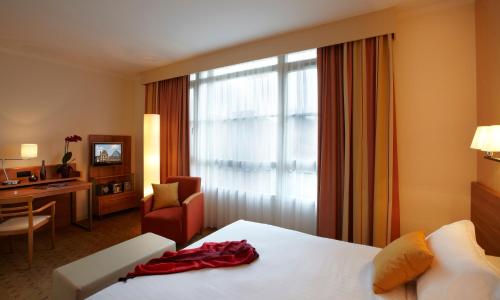 a hotel room with a bed and a chair and a window at Citadines Saint-Germain-des-Prés Paris in Paris