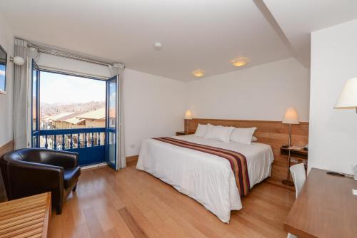 a hotel room with a bed and a balcony at Hotel Plaza de Armas Cusco in Cusco