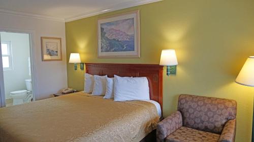 una camera d'albergo con letto e sedia di Redondo Inn and Suites a Redondo Beach