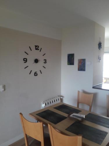 a dining room table with a clock on the wall at ESPECTACULAR Alem 5007 piso 7 in Mar del Plata