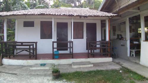 a small house with a porch with two chairs at Dahilig Resort in Puerto Galera