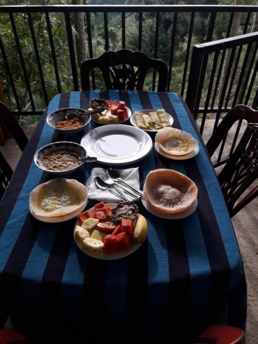 a blue table with plates of food on it at adam's apple homestay in Ella