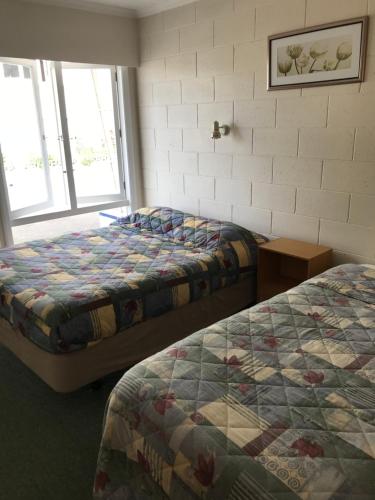 a hotel room with two beds and a window at Picton House B&B and Motel in Picton