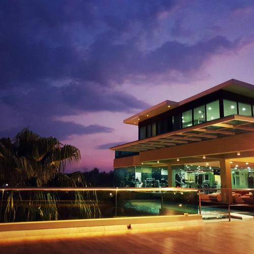 a building with a pool in front of it at night at The Beverly Hills Hotel in Nakhon Ratchasima