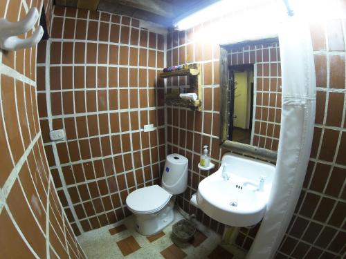 a small bathroom with a toilet and a sink at Finca Campestre La Adelita B&B in Salento