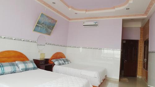 a room with two beds and a picture on the wall at Rang Dong Hotel in My Tho