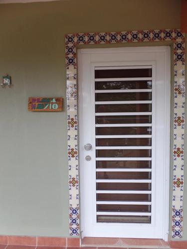 a front door of a house with flowers around it at Isla Hermosa Guesthouse in Vieques