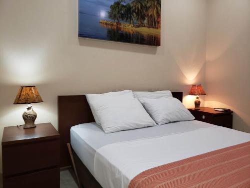 a bedroom with a bed with two nightstands and two lamps at The Balboa Inn in Panama City
