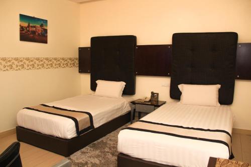 two beds in a room with two beds sidx sidx sidx sidx at Shervinton Executive Boutique Hotel in Tawau