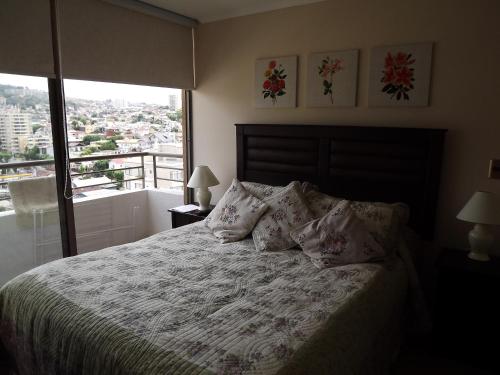 1 dormitorio con cama con almohadas y ventana en Departamento En Viña Del Mar, en Viña del Mar